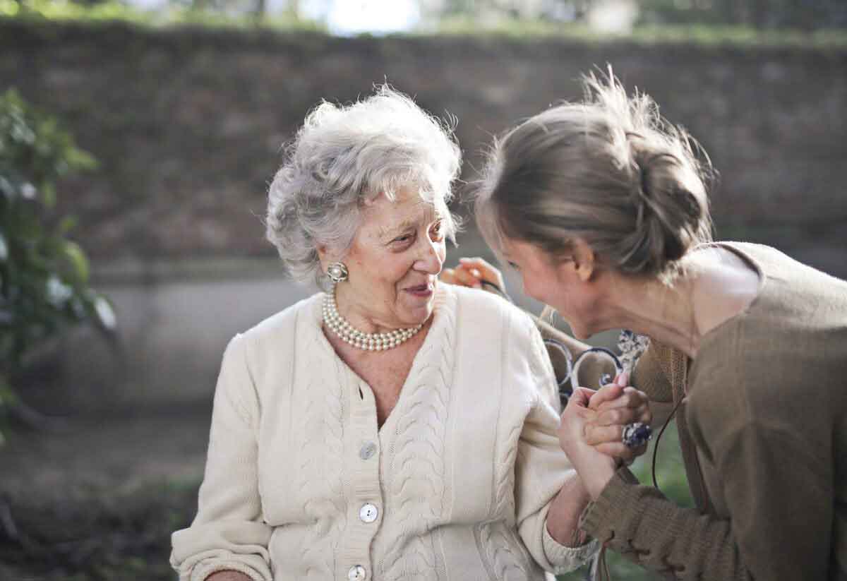 Elderly woman being cared for by her younger guardian